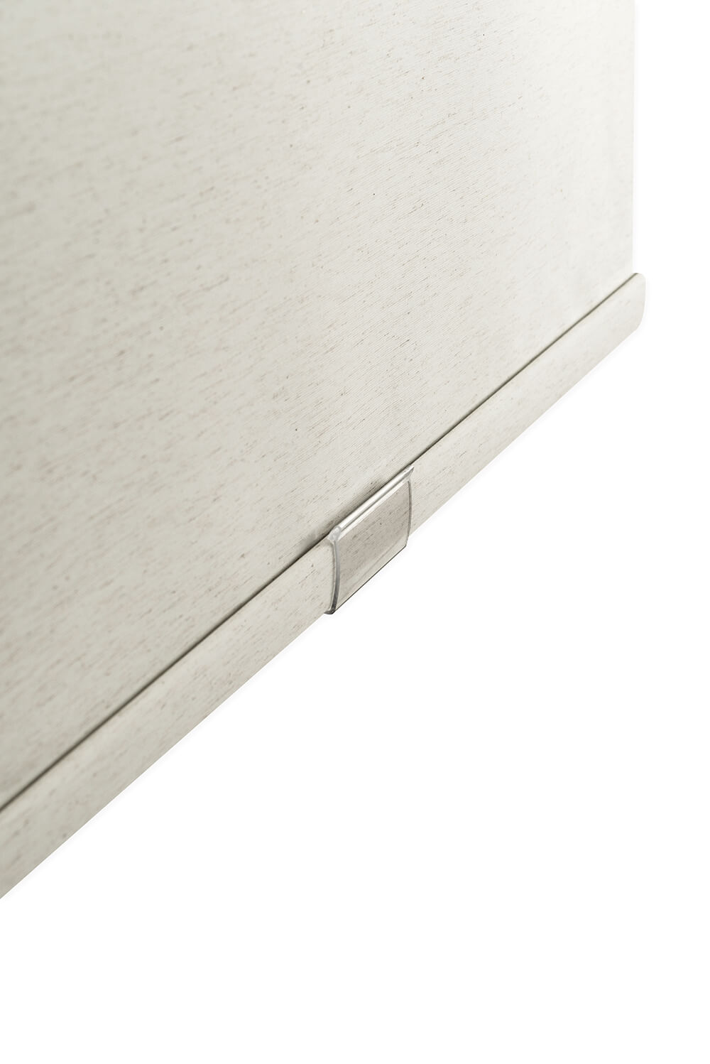 Close-up of a textured beige surface with a metallic handle on a white background