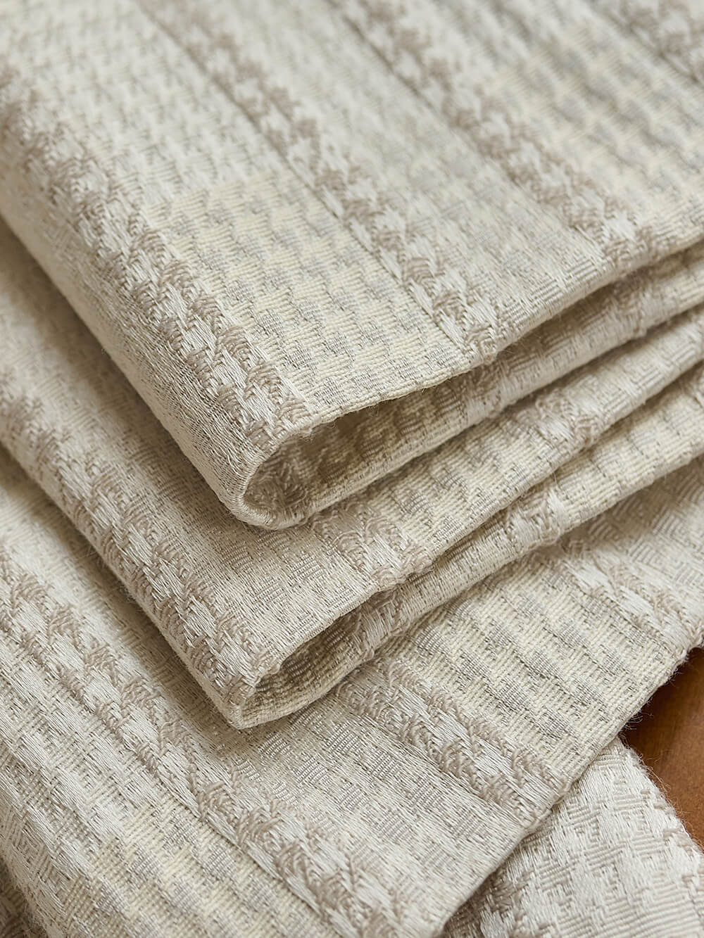 Stack of beige textured fabric swatches